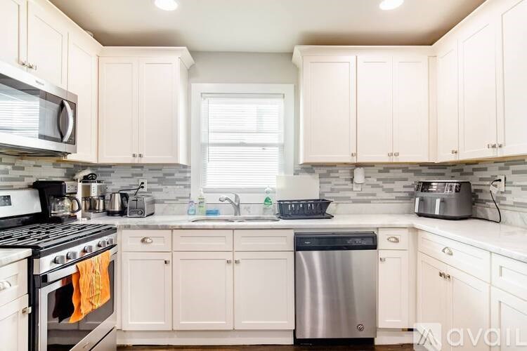 A kitchen with white cabinets and a black stove top.