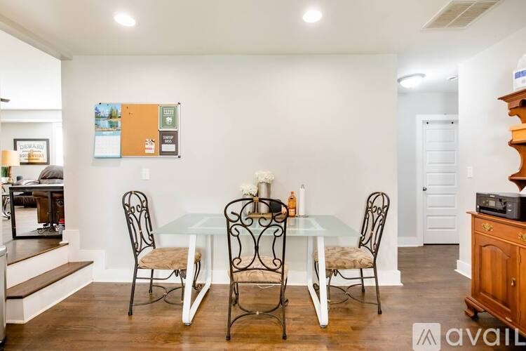 A dining room with a glass table and chairs.