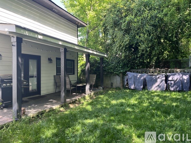 A house with a covered patio and a green lawn.
