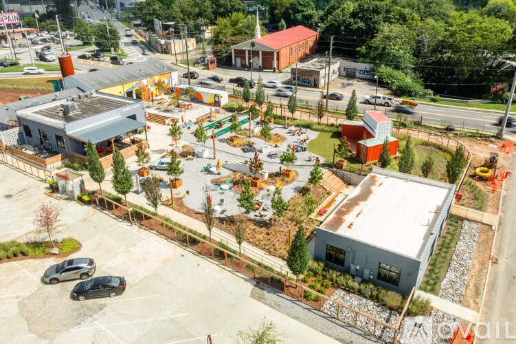 A parking lot with a building and a tree in front of it.