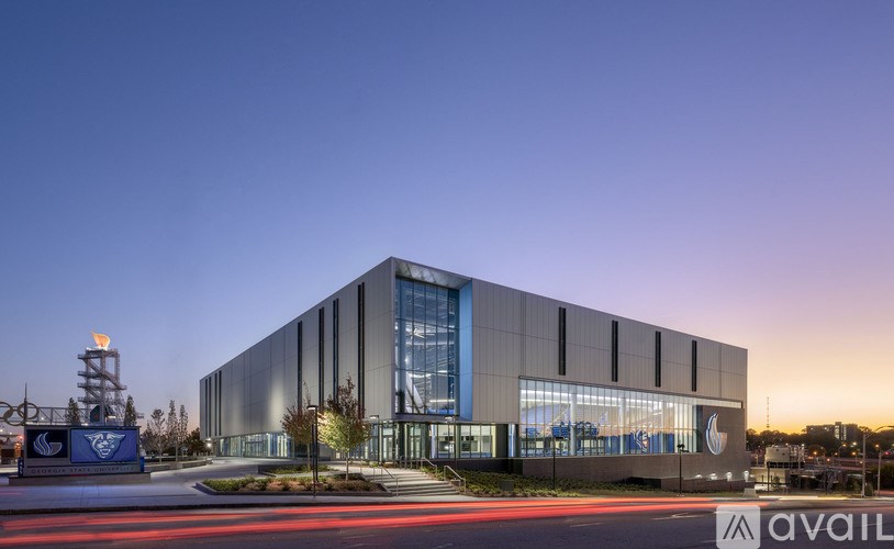 A modern building with a large glass window and a logo on the front.