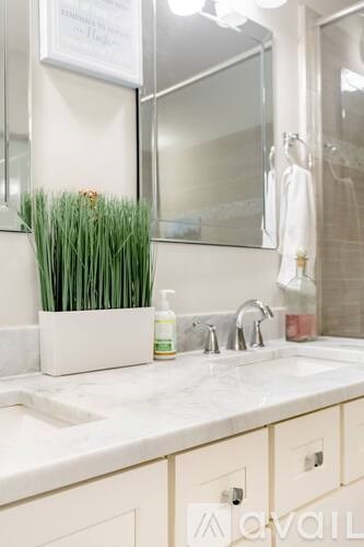 A bathroom with a sink, mirror, and a sign on the wall.