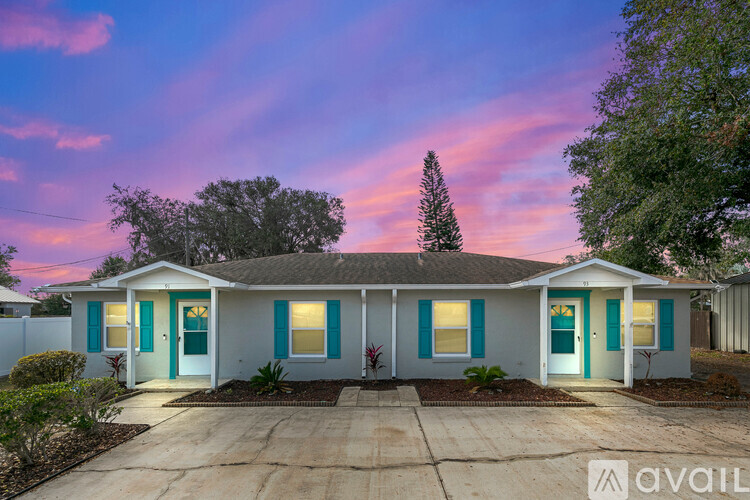 A house with a blue door and a white fence is available for sale.