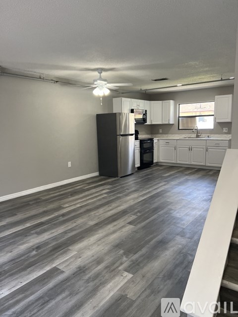 A kitchen with a refrigerator, microwave, and oven.