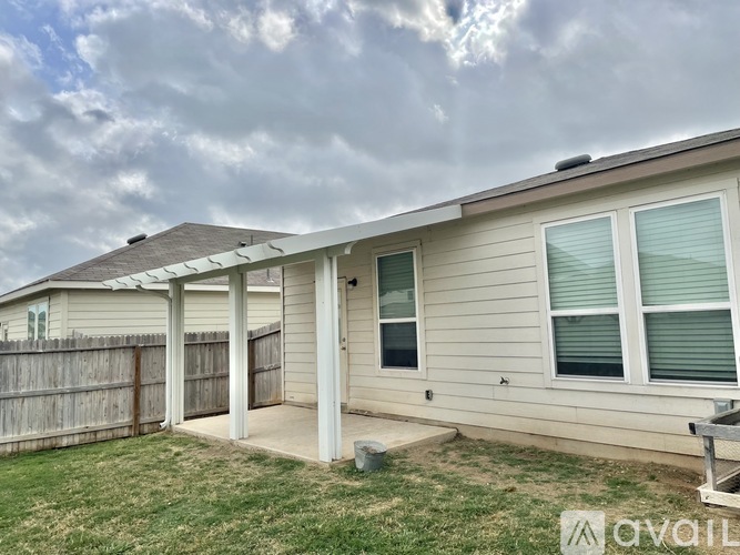 A house with a fence and a covered patio area is for sale.