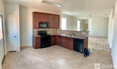 A kitchen with brown cabinets and black appliances.