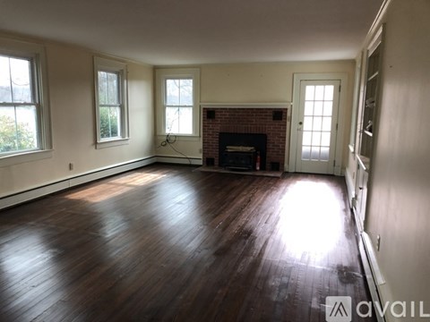 A room with a fireplace and wood flooring.