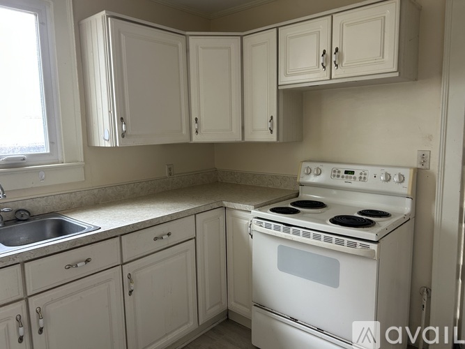 A white kitchen with a stove and cabinets.