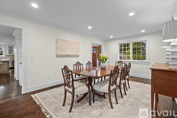 A dining room with a round table and chairs.