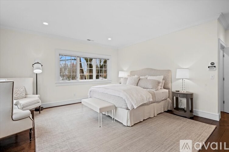A bedroom with a large bed and a chair.