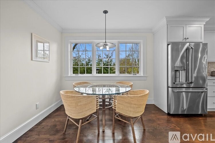 A modern kitchen with a glass table and chairs.