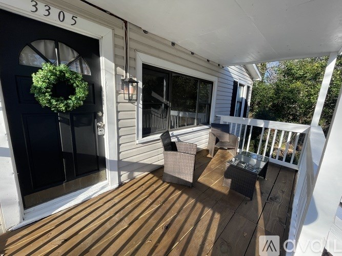 A porch with a wreath on the door and a table and chairs on the deck.