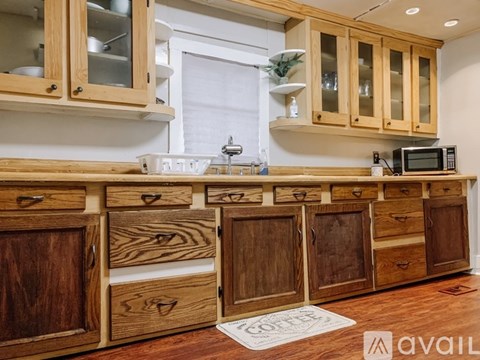 A kitchen with wooden cabinets and drawers is available for rent.