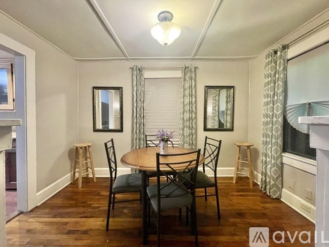 A dining room with a wooden table and chairs.