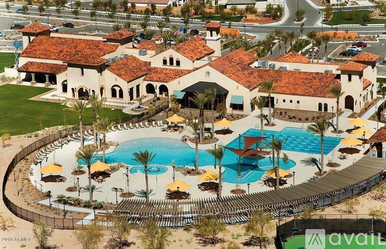A large resort with a pool and a building with a red roof.