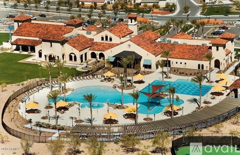 A large resort with a pool and a building with a red roof.