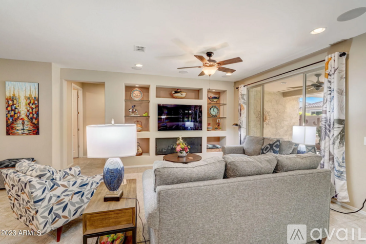 A living room with a grey couch and a patterned armchair.