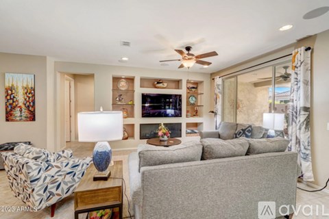 A living room with a grey couch and a patterned armchair.