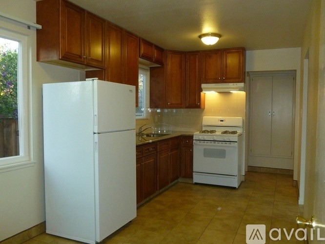A kitchen with white appliances and wooden cabinets.