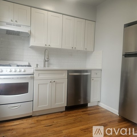 A kitchen with white cabinets and a stainless steel dishwasher.
