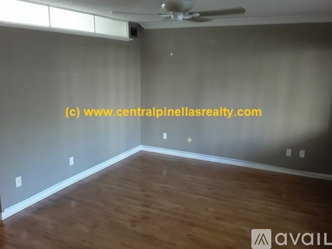 A room with wooden flooring and a ceiling fan.