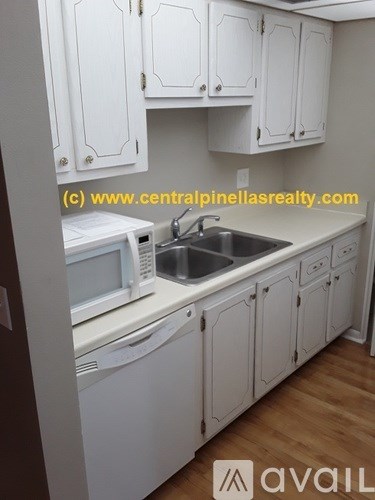 A kitchen with white cabinets and appliances.