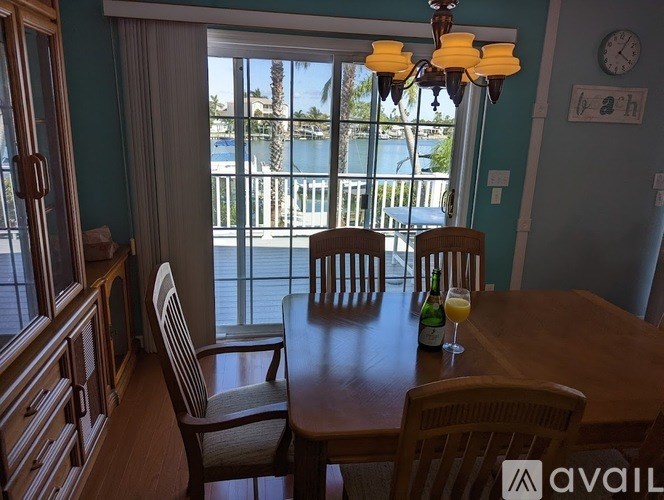 A dining room with a table set for two and a view of the water outside.