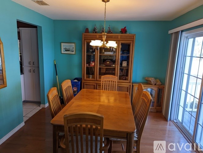 A dining room with a wooden table and chairs.