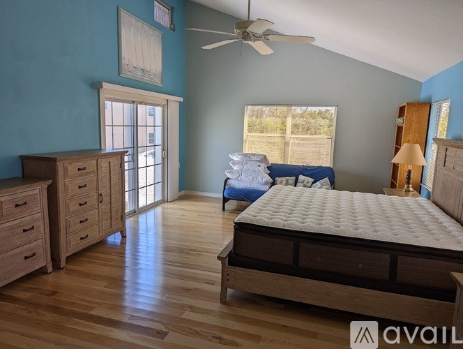A bedroom with a bed, dresser, and ceiling fan.
