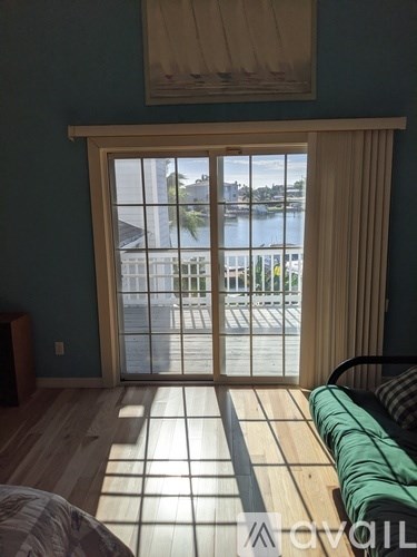 A room with a sliding glass door leading to a balcony.