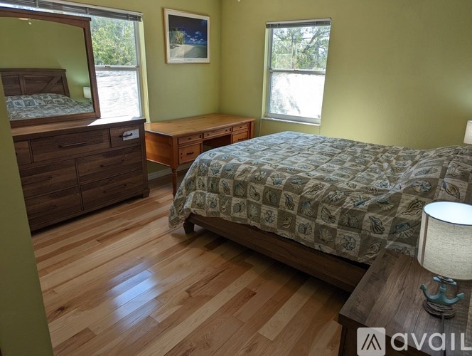 A bedroom with a bed, a dresser, and a nightstand.
