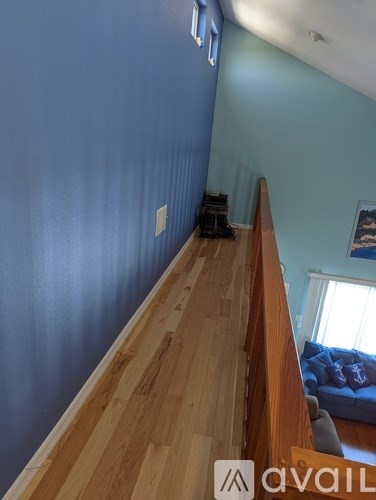 A long hallway with wood floors and blue walls.
