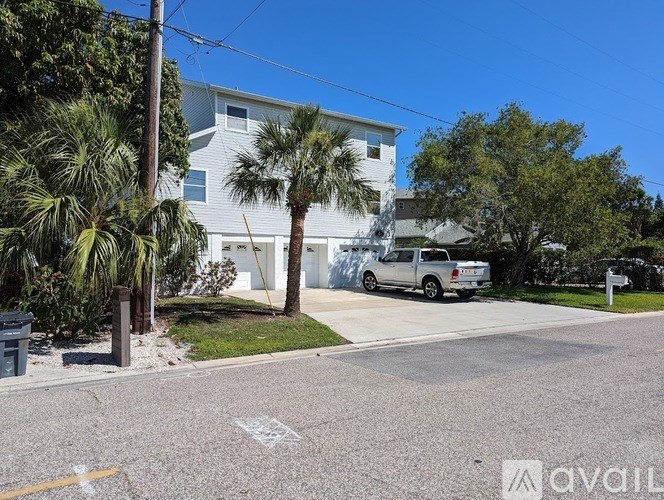 A white building with a grey roof and a white van parked in front of it.