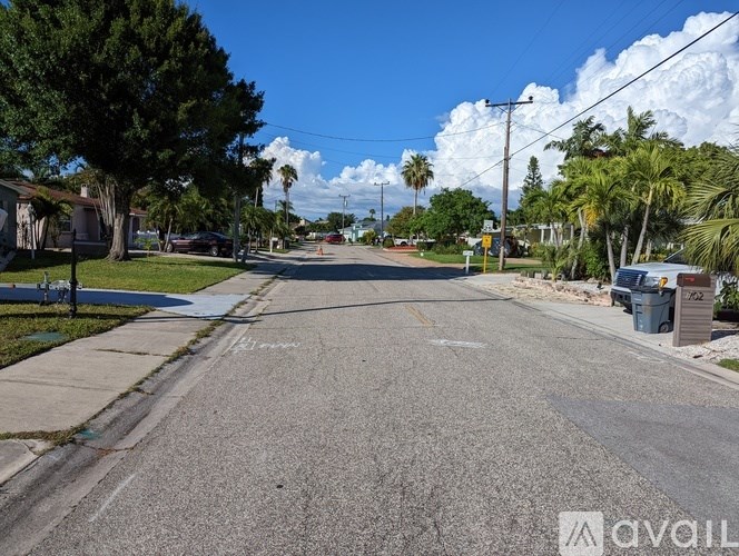 A street view with a clear sky and a few trees on the side.