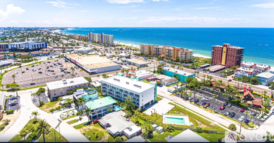 A view of a coastal town with buildings, roads, and the ocean in the background.