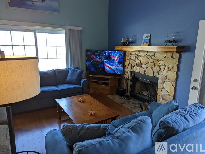 A living room with a fireplace and a television on a stand.