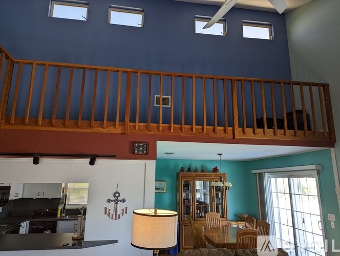 A living room with a balcony and a dining area.