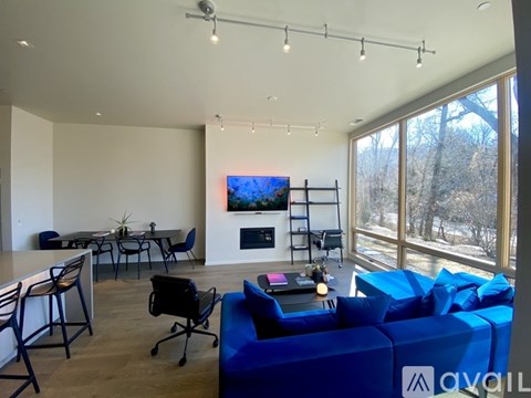 A living room with a blue couch and a television on the wall.