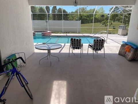 A patio with a table, chairs and a bicycle.