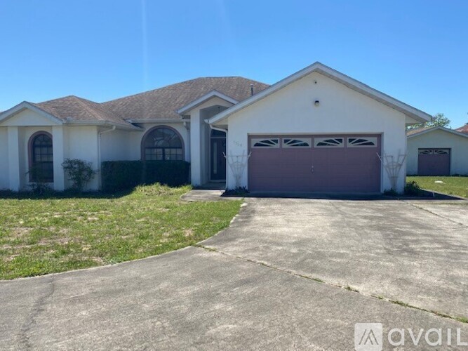 A two-story house with a garage door and a driveway.
