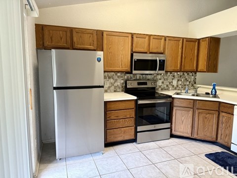 A kitchen with wooden cabinets and a stainless steel refrigerator.