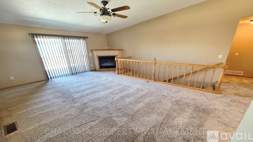 A living room with a ceiling fan and a flat screen TV.