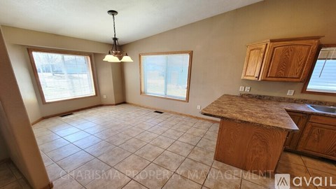 A kitchen with wooden cabinets and a tiled floor.