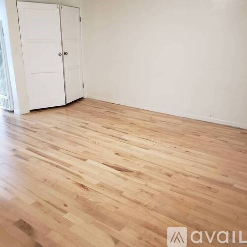 A room with wooden flooring and a white door.