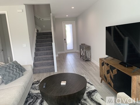 A living room with a grey couch and a wooden coffee table.