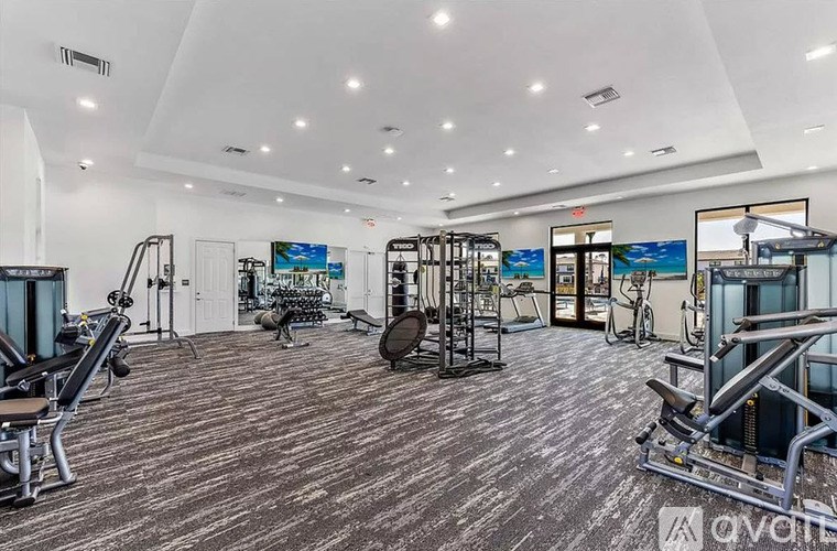 A gym with a variety of equipment including treadmills, weights, and exercise machines.