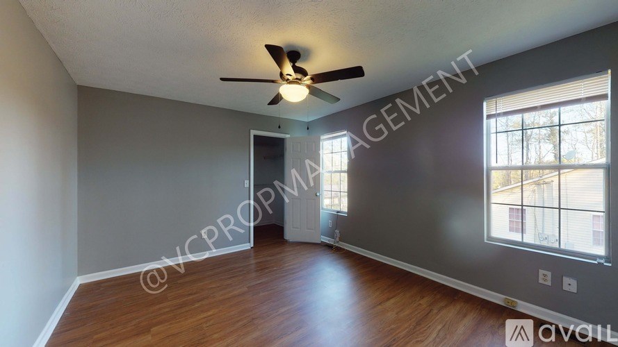 A room with a ceiling fan and wooden flooring.