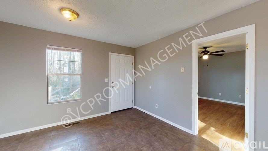 A room with a ceiling fan and a window.