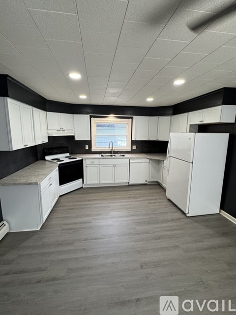 A kitchen with white cabinets and a window.