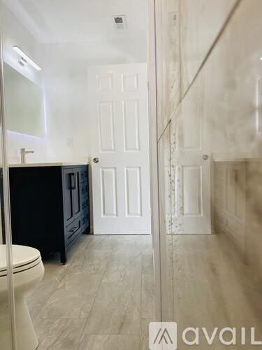 A bathroom with a toilet, sink, and mirror.